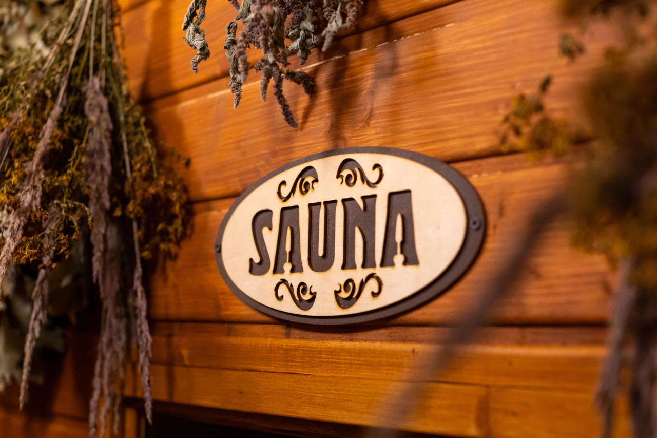 Dried herbs on wooden background with inscription sauna